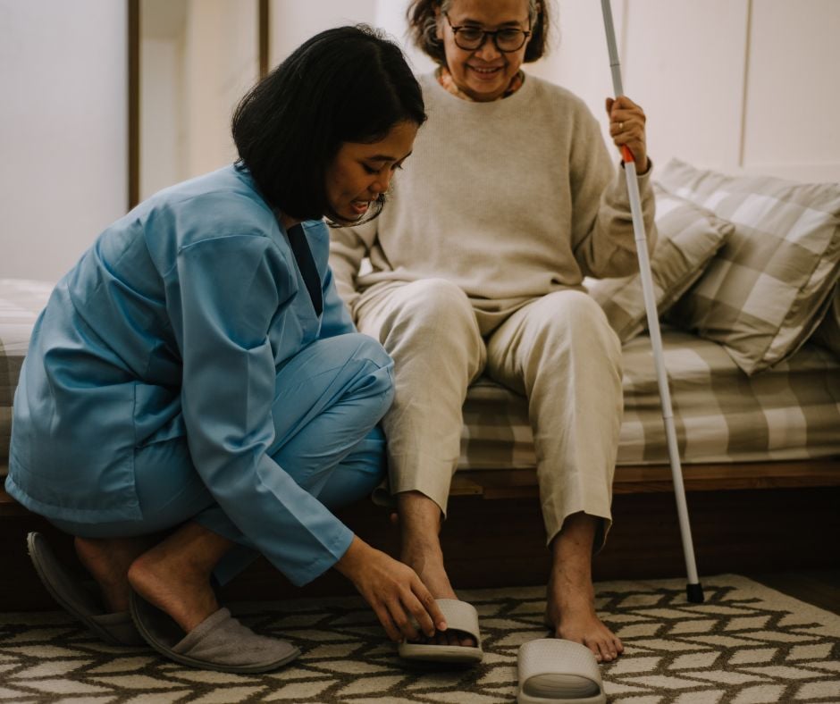 nurse helping the woman with her shoes